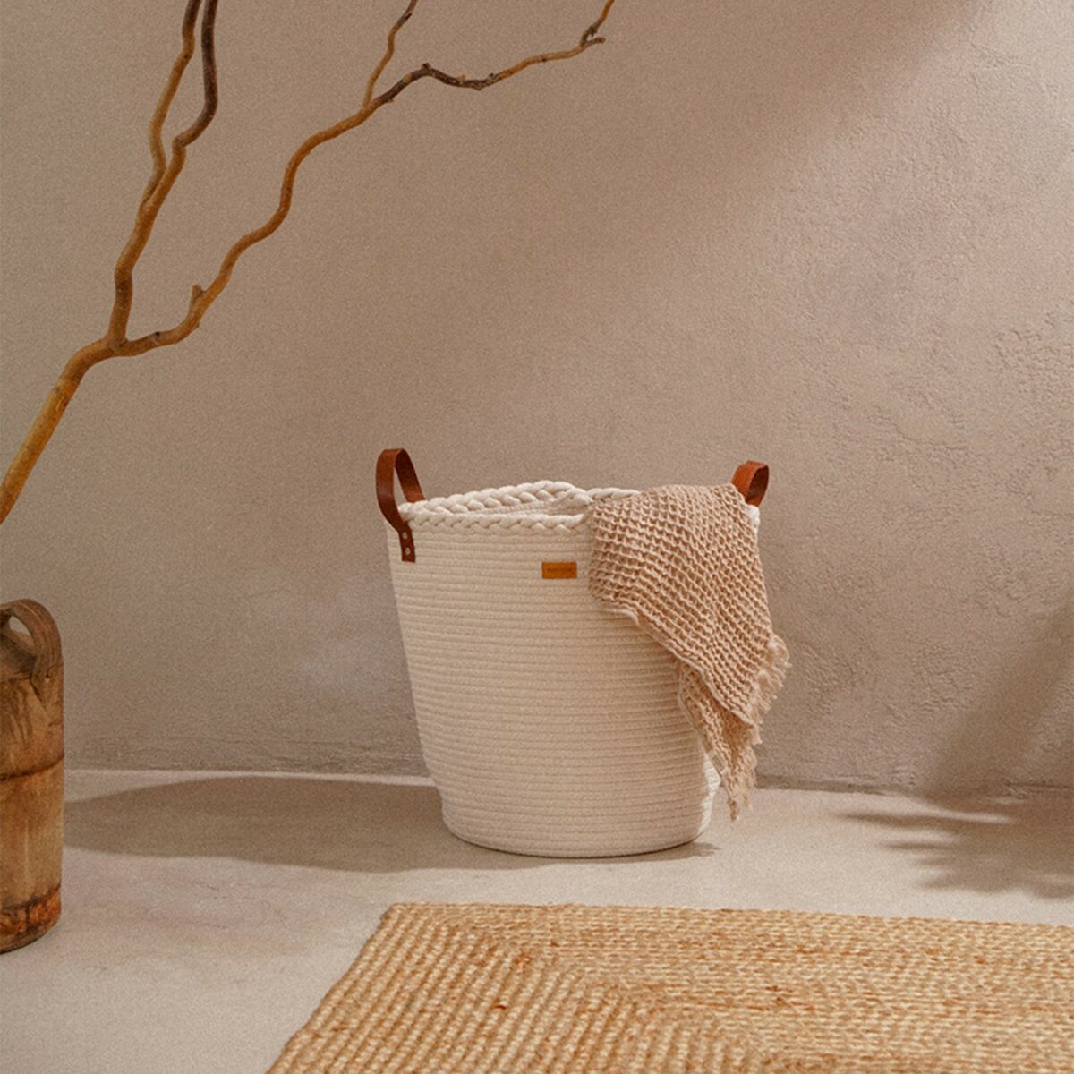 Белая круглая текстильная корзина для белья с плетением и ручками 35×40 см Круглая белая текстильная корзина для белья из хлопка с кожаными ручками на светлом фоне