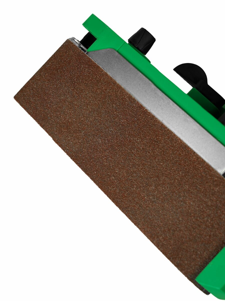 Крупнозернистый абразивный инструмент с коричневой шлифовальной поверхностью и черными элементами управления на зеленом корпусе