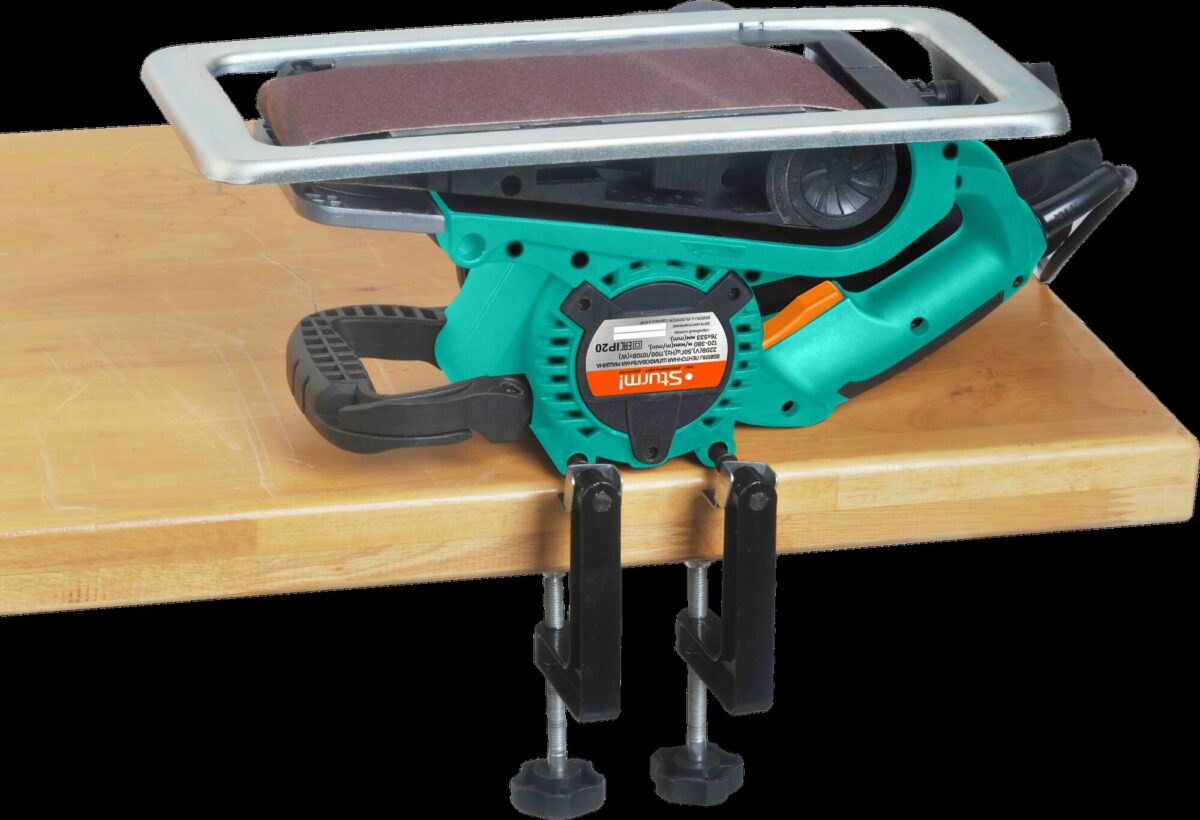 Ленточный шлифовальный станок Sumake BR2152Q в зелёно-чёрном корпусе, закреплённый на столе с помощью двух струбцин