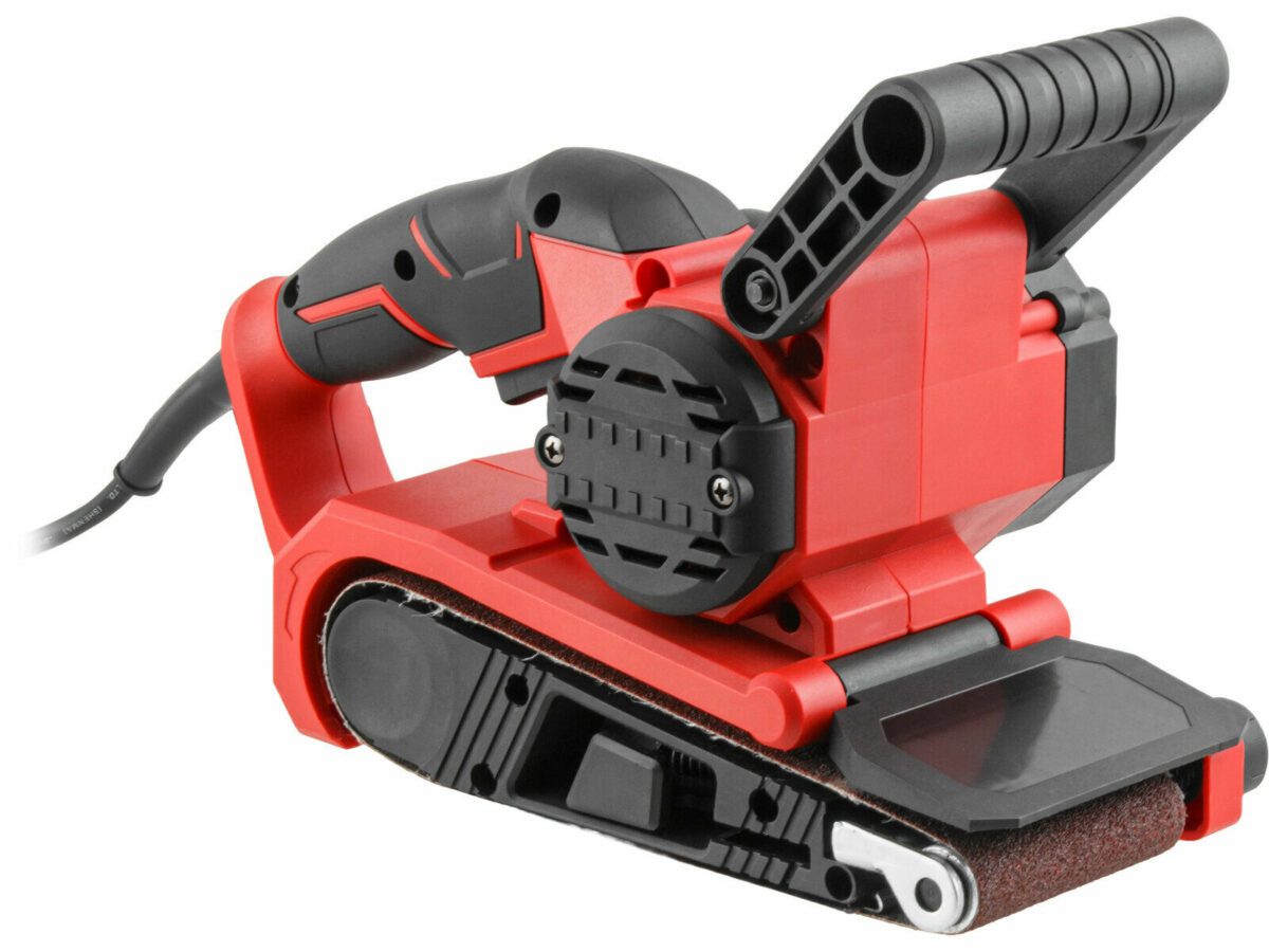 Ленточная шлифовальная машина красного цвета с черными элементами, оборудованная шлифовальной лентой и удобными ручками, на фоне электрического кабеля