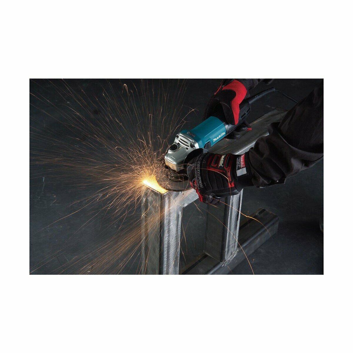 Человек использует угловую шлифовальную машину Makita для обработки металлической конструкции, искры летят от точки контакта