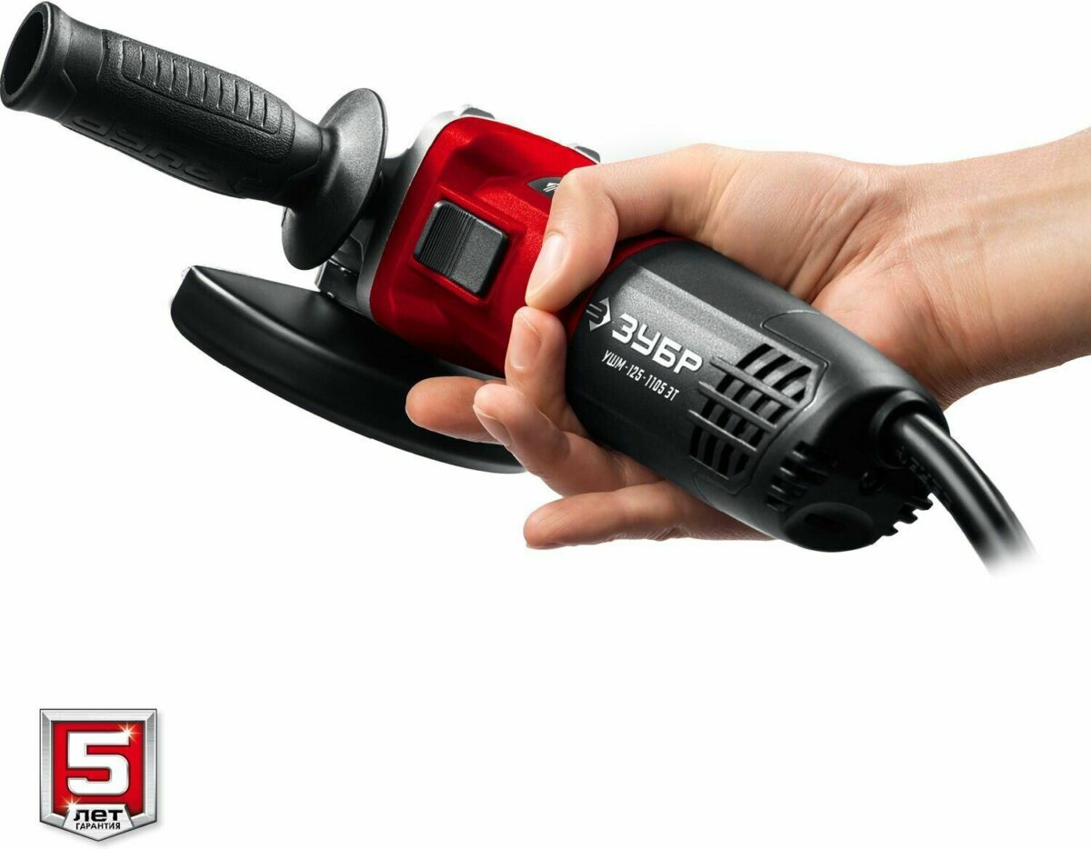 УШМ Зубр УШМ-125-1105 ЭТ красного и черного цвета с кругом диаметром 125 мм в руке, гарантия 5 лет