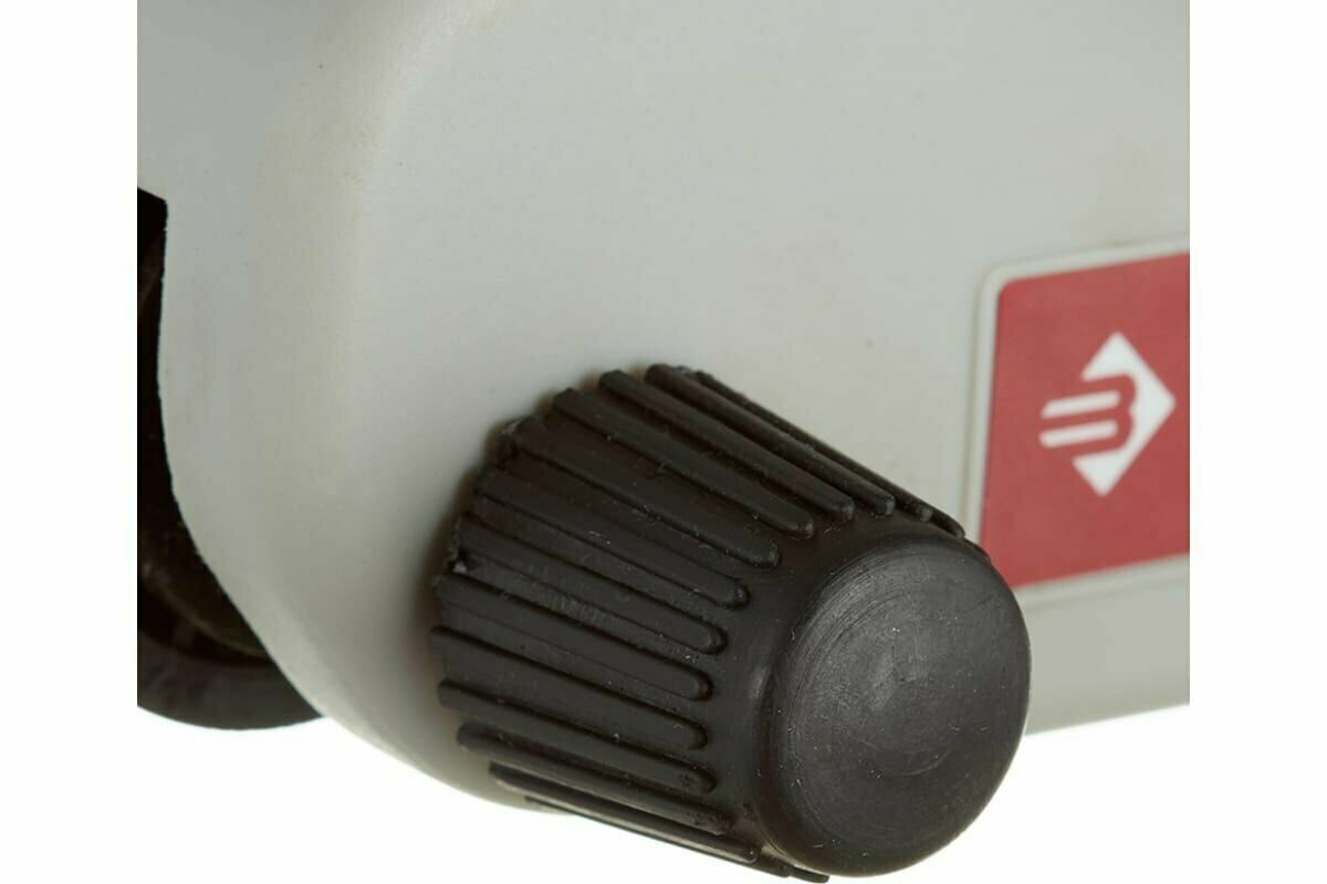 Ребристая черная ручка регулятора на сером устройстве с красным полем и белым логотипом в виде стрелки