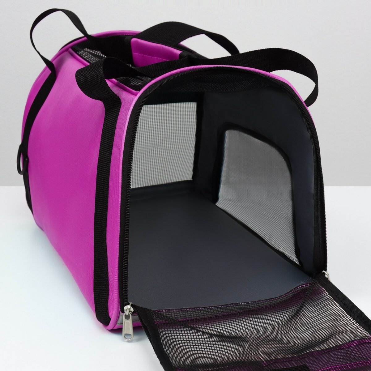 Функциональная фиолетовая сумка-переноска с сетчатой вентиляцией для животных Фрагмент фиолетовой сумки-переноски с сетчатой вентиляцией и креплениями, предназначенной для комфортной перевозки животных