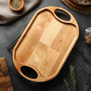 Деревянный кухонный поднос ручной работы с бортиками и овальными ручками на фоне кухонной столешницы