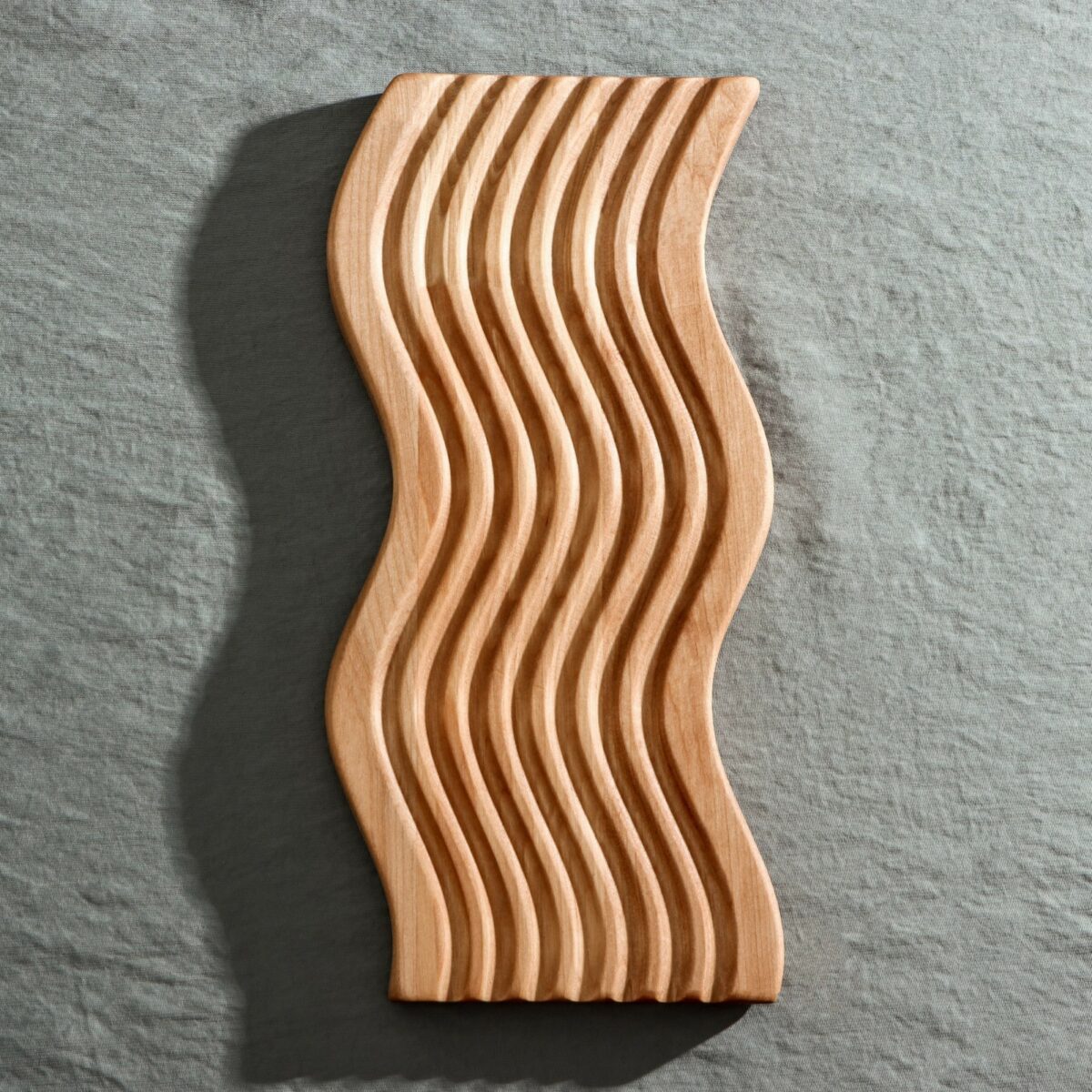 Красивая деревянная доска для подачи с волнообразными изгибами, выполненная из берёзы