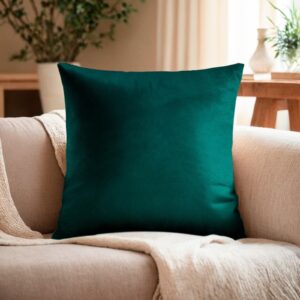 Квадратная декоративная подушка 30×30 см из велюра глубокого изумрудного цвета, расположенная на светлом диване в уютной домашней обстановке