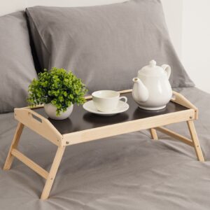 Складной поднос для завтрака из натурального дерева с тёмной столешницей, боковыми ручками и складными ножками на фоне спальни