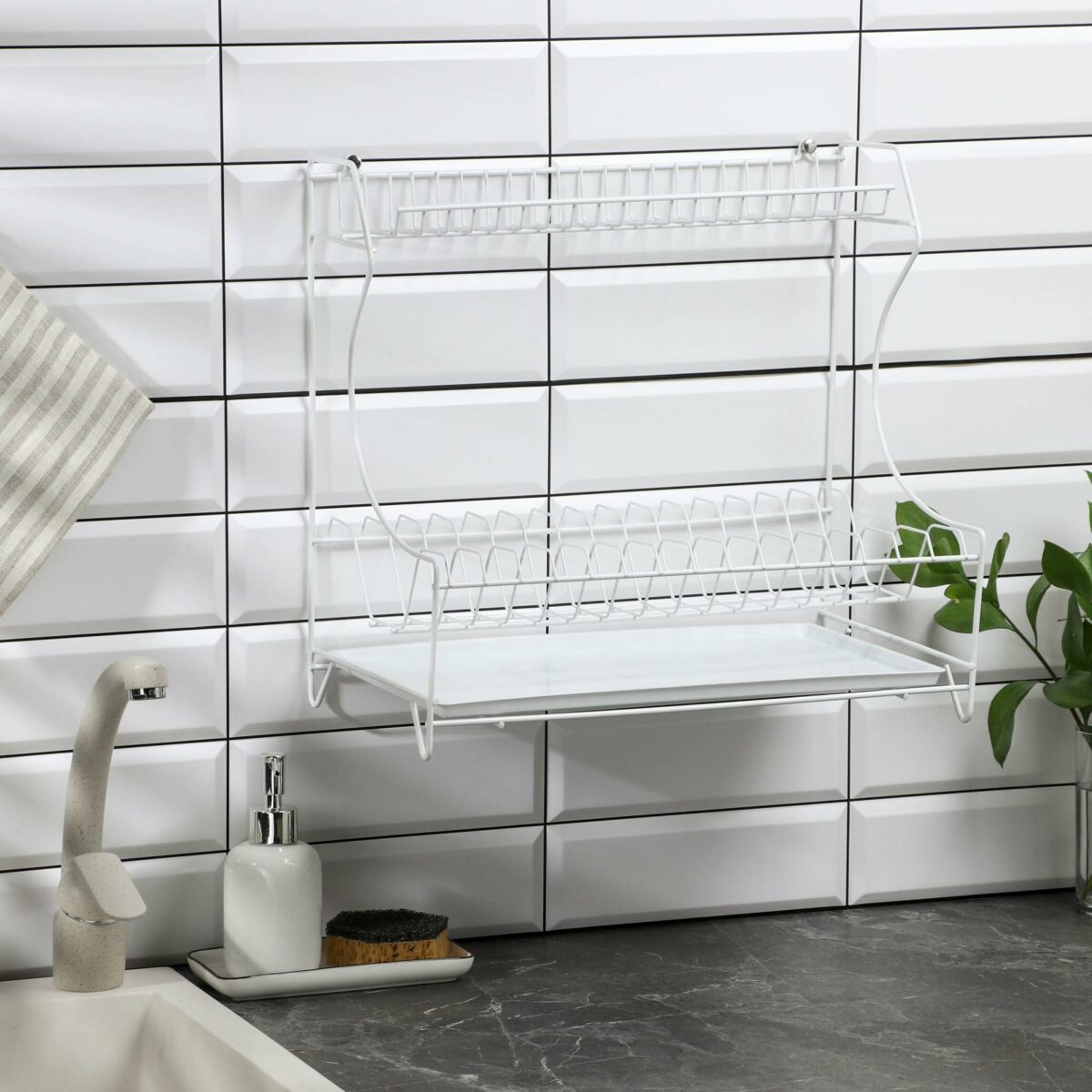 Двухъярусная белая настольная металлическая сушилка для посуды с поддоном для кухни Белая металлическая двухъярусная сушилка для посуды с поддоном и креплениями для настенного размещения, расположенная на современной кухне