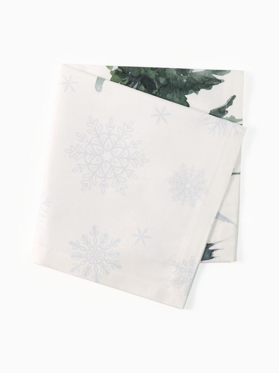 Набор стильных сервировочных салфеток из ткани с узором снежинок и лесным дизайном 40×40 см Сервировочные салфетки 40x40 см из набора с белым фоном, снежинками и лесным рисунком в зелёных оттенках