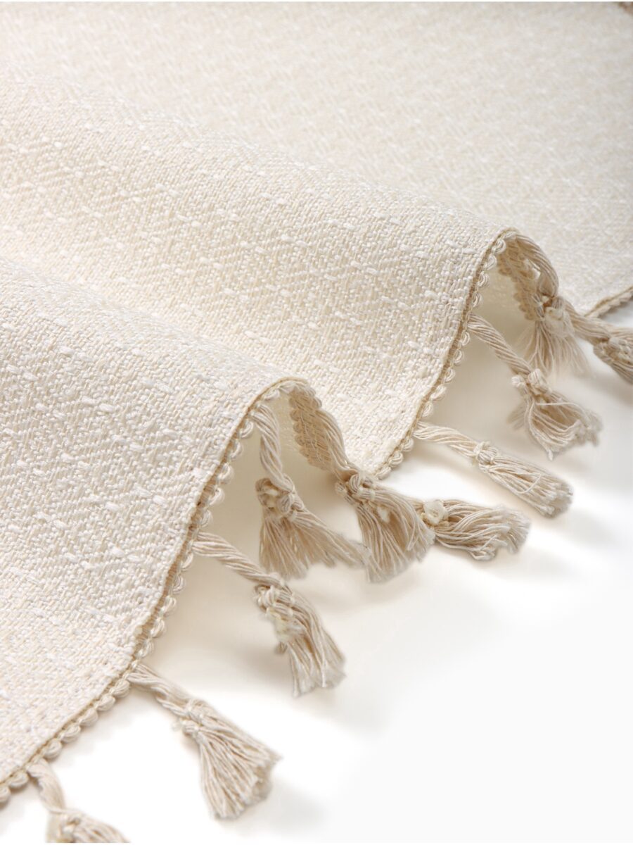 Маслоотталкивающая скатерть с нейтральным дизайном — идеальный текстильный аксессуар для праздничного украшения стола Фрагмент светлой текстурированной ткани для скатерти с плетением и необработанным краем, подходящей для новогоднего декора и праздничного использования