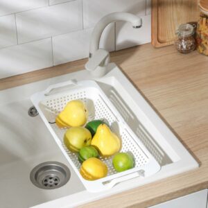 Раздвижная сушилка белого цвета с поддоном, установленная на кухонной раковине, с фруктами для демонстрации универсального использования