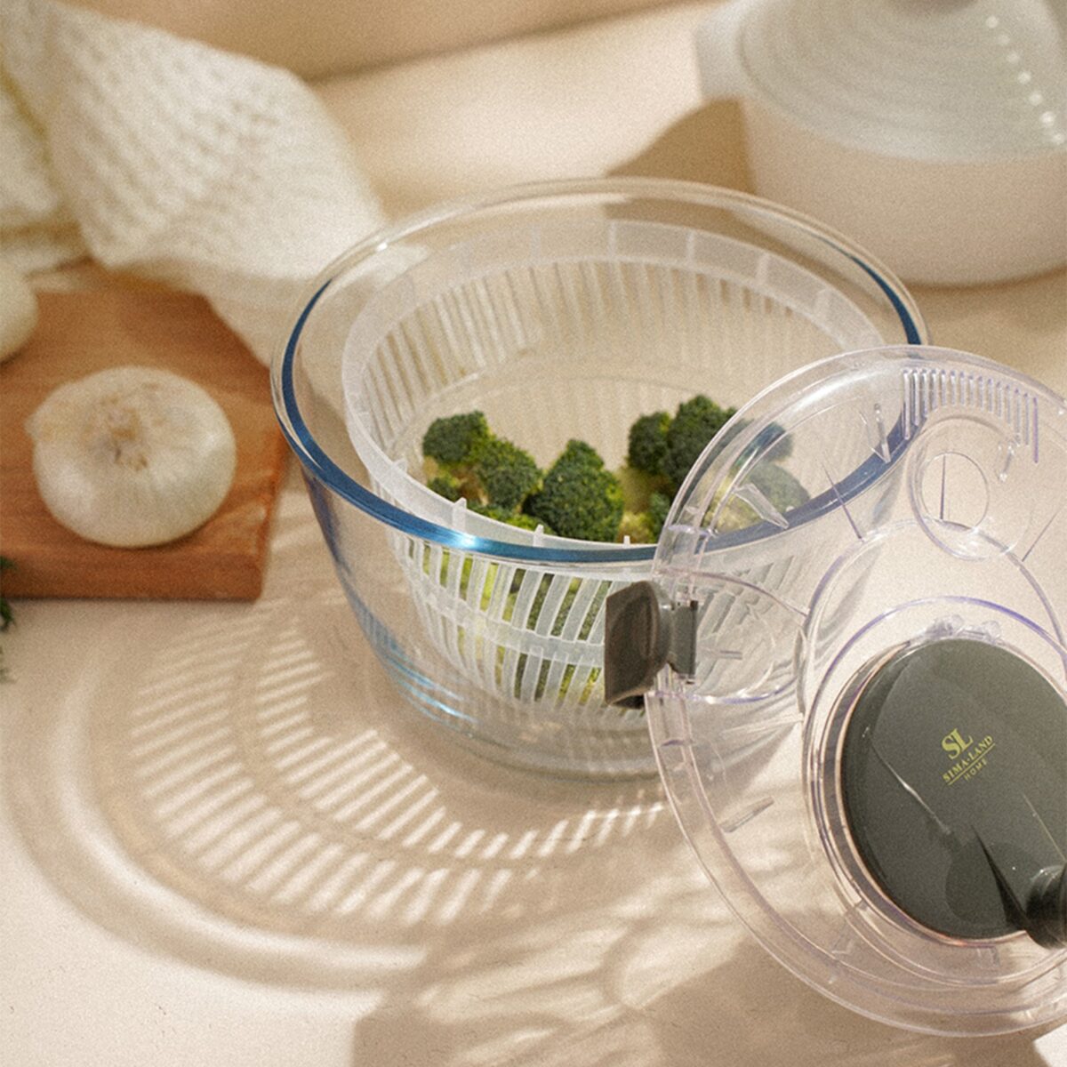 Центрифуга для сушки зелени объем 5 литров из стекла с перфорированным контейнером Центрифуга для сушки зелени объем 5 литров с прозрачной стеклянной чашей, оливковыми элементами и брокколи внутри
