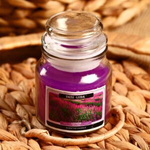 Фиолетовая ароматическая свеча в прозрачной стеклянной банке с крышкой, аромат лаванда, на деревянной поверхности с элементами декора