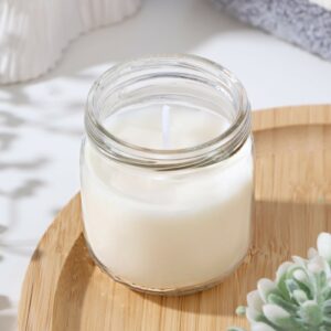 Ароматическая свеча в прозрачной банке с белым фитилем на деревянной поверхности, окружённая элементами декора