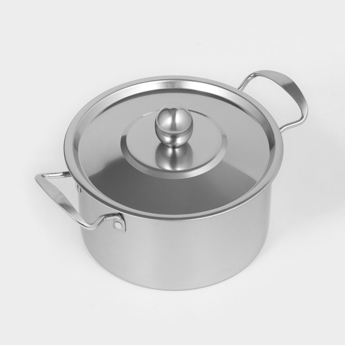 Кастрюля из нержавеющей стали с плоской крышкой и металлическими ручками Кастрюля цилиндрической формы из нержавеющей стали с плоской крышкой и эргономичными металлическими ручками на матовой поверхности